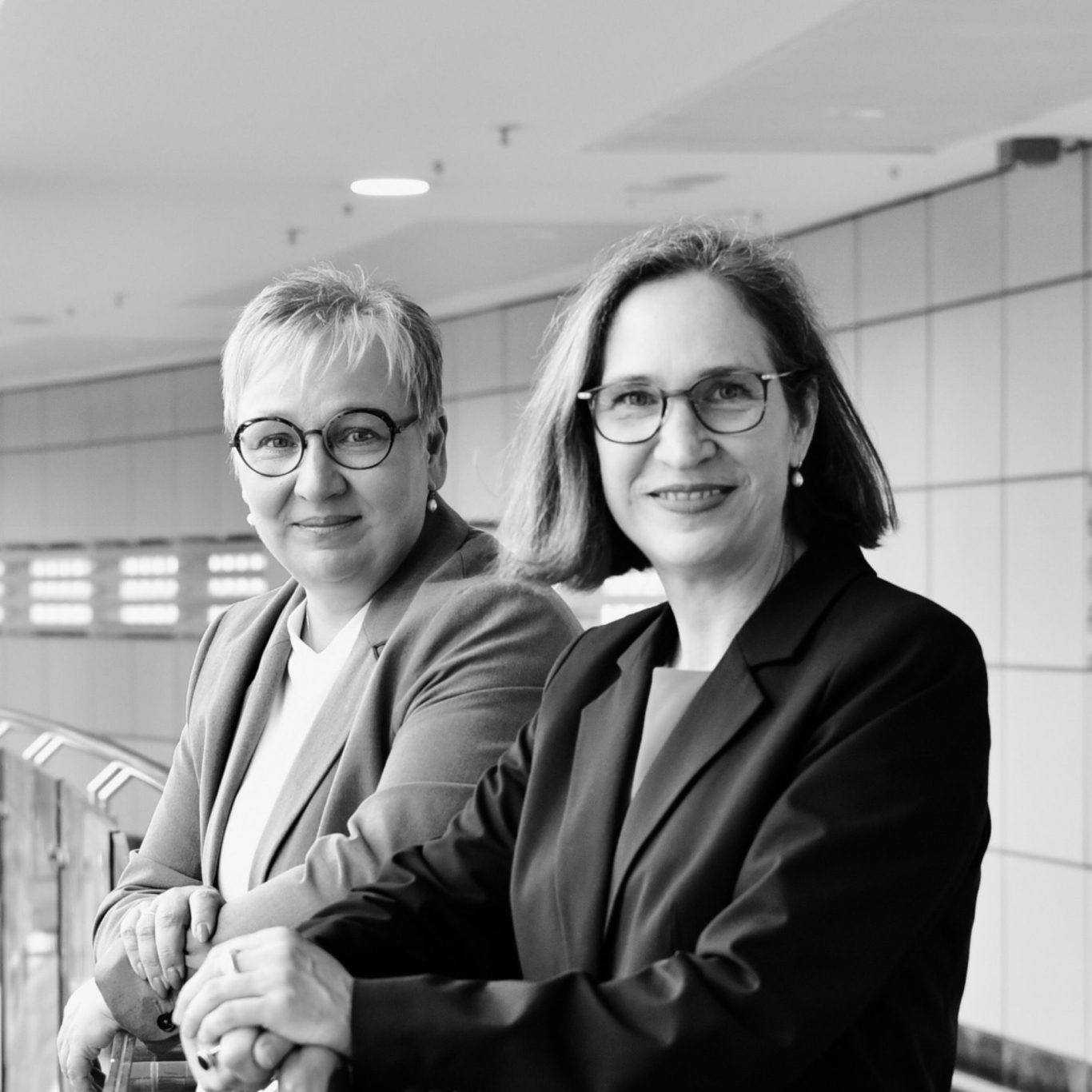 Iris Bothe und Petra Ringmann stehen nebeneinander und blicken selbstbewusst in die Kamera.